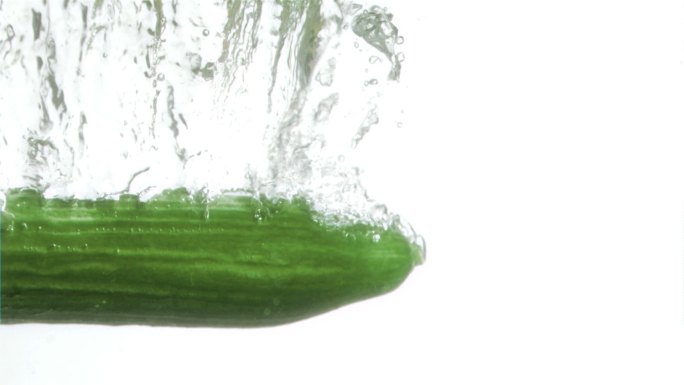 半根黄瓜在白色背景下以超慢的动作落进水里