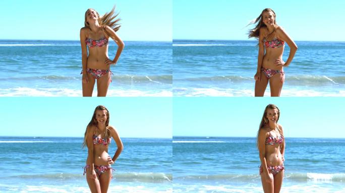 在慢镜头中，年轻女子在沙滩上甩动她的头发
