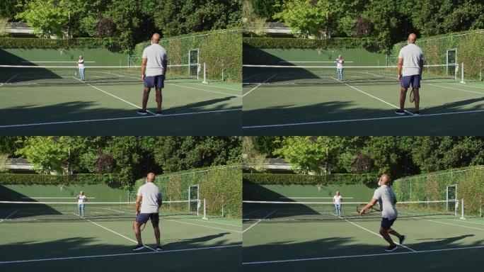 一对非裔美国老年夫妇在一个阳光明媚的日子里在网球场上打网球