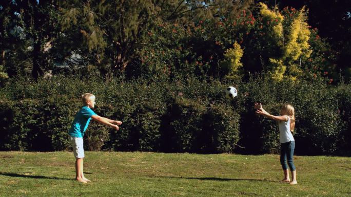 在公园里哥哥把足球扔给妹妹特写