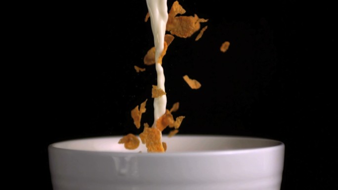 麦片和牛奶倒入碗里特写