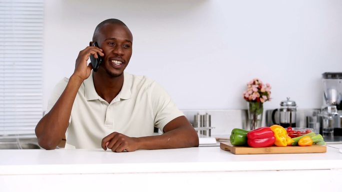 一个男人坐在厨房里打电话特写