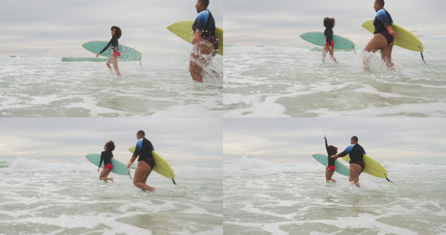快乐的非裔美国女性朋友们抱着冲浪板奔向大海