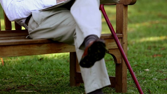 一位老人坐在公园的长椅上特写