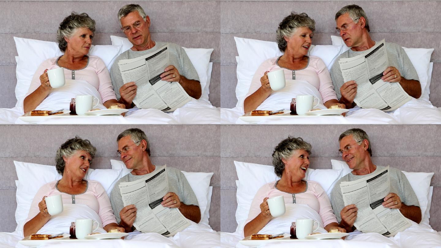 丈夫边吃早饭边给妻子读报纸