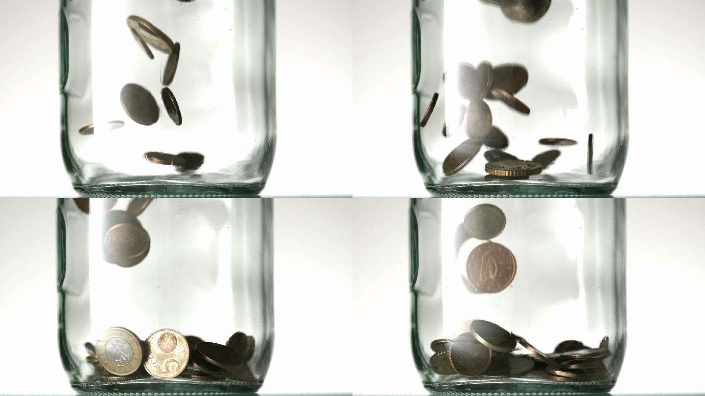 硬币掉落进了一个玻璃罐子特写