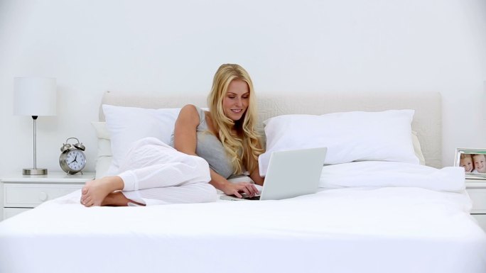 女人躺在床上看电脑特写
