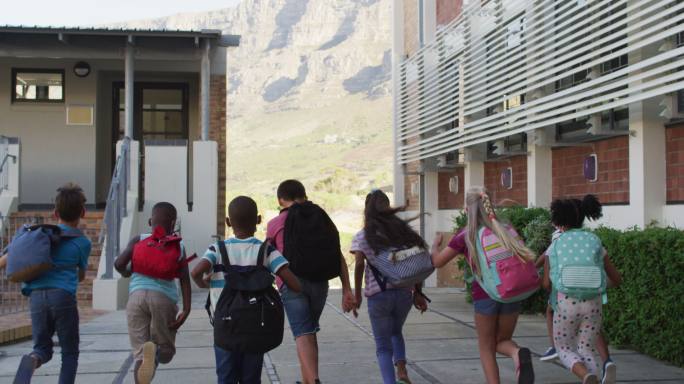 放学后，一群背着背包蹦蹦跳跳跑回家的快乐学童