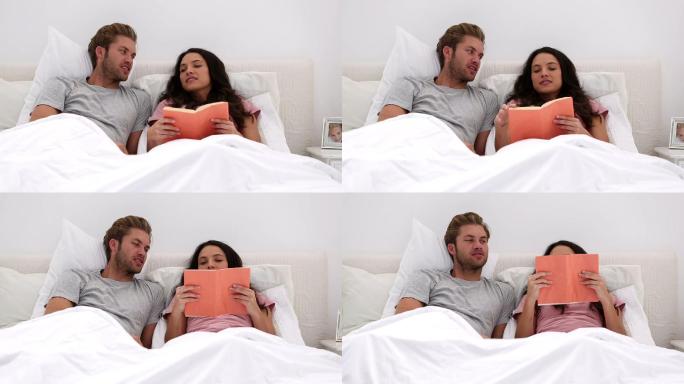 一对夫妇躺在床上看书特写