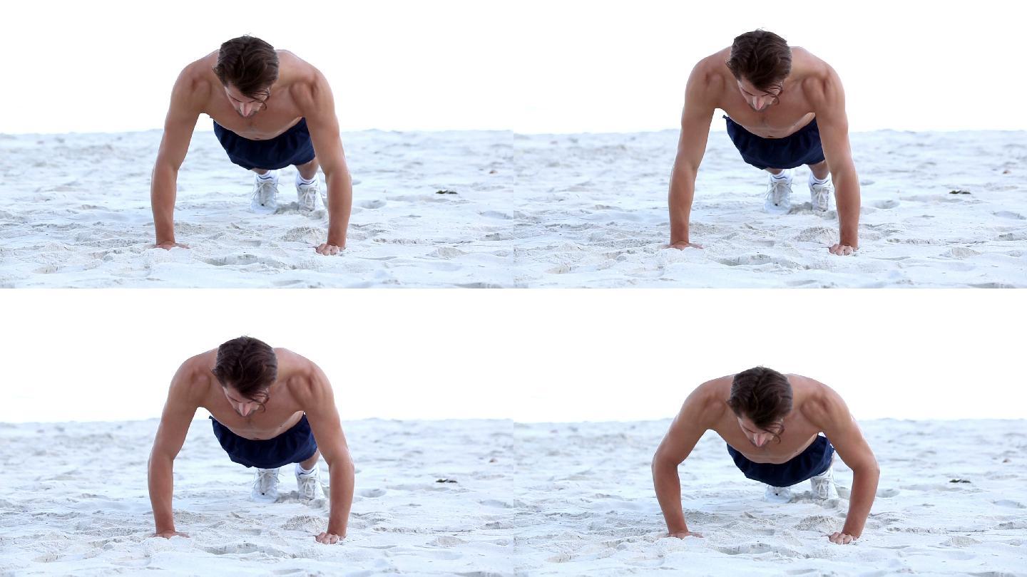 一个男人在海滩上做俯卧撑特写