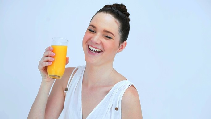 女人在白色背景下喝橙汁特写