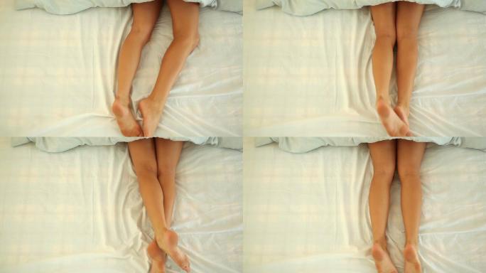 女人的腿躺在床上，铺着白色的床单