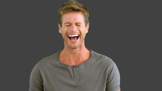 一个男人在灰色屏幕上用慢镜头笑着