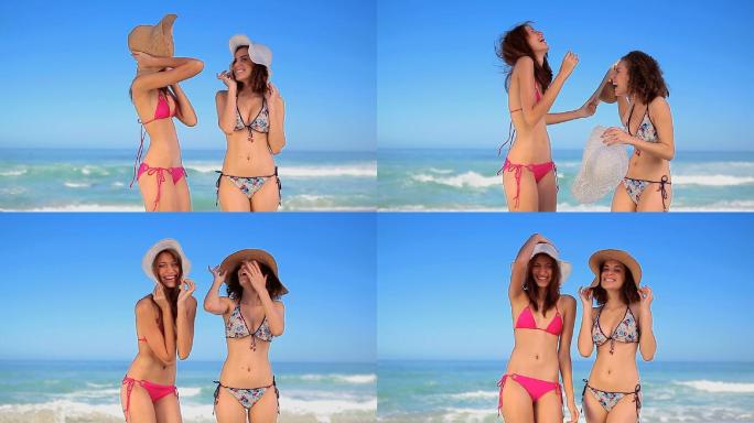 两个女人戴着草帽站在海滩上特写