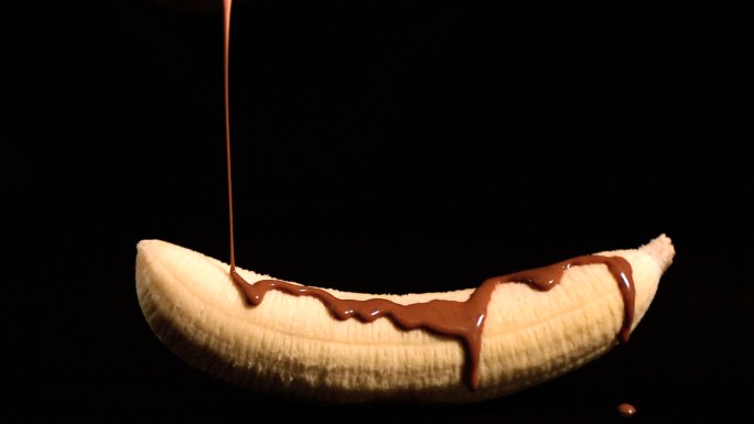 融化的巧克力倒在香蕉上特写
