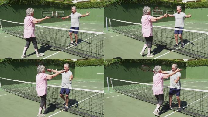 快乐的白人老年夫妇在打完一场比赛后拥抱在室外网球场的网
