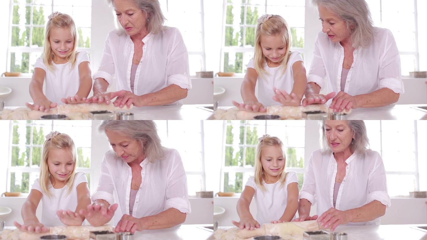奶奶和孙女在厨房用擀面杖特写