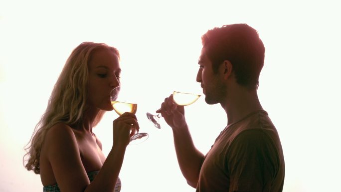 一对夫妇在阳光下一起喝酒的慢镜头