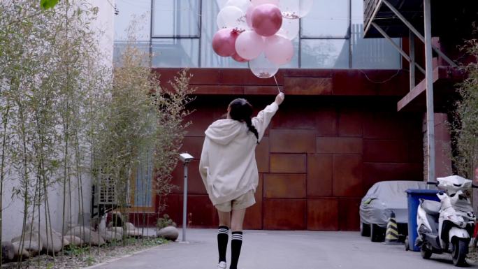 快乐年轻女孩拿着气球的背影