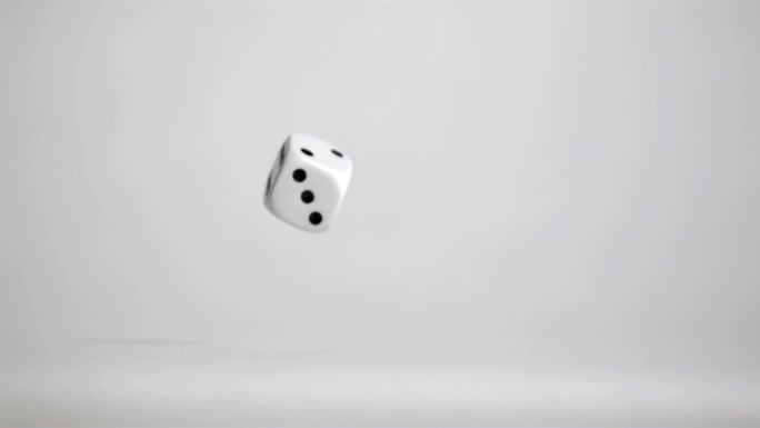 一颗白色的骰子掉落转动特写