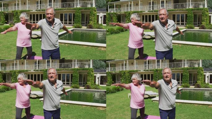 快乐的白种人老夫妇在花园练习瑜伽站在阳光下伸展