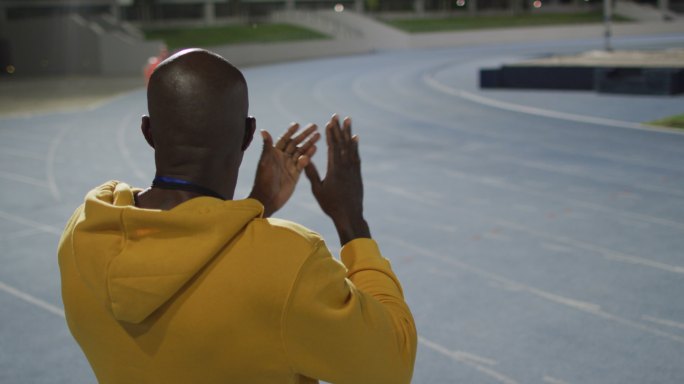 非洲裔美国男教练鼓掌观看残疾男运动员与跑步刀片训练