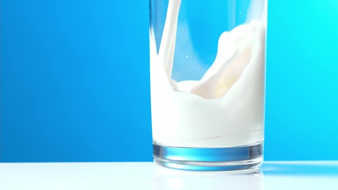 牛奶倒入玻璃杯中液体白色光影