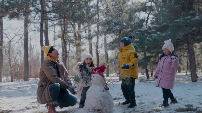 快乐家庭在雪地里堆雪人