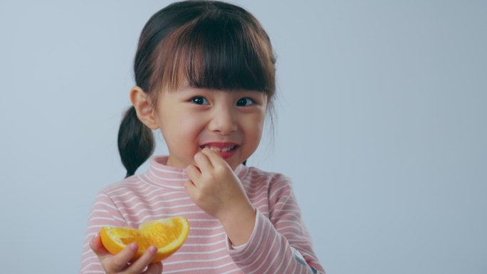 吃橙子的小女孩三胎二孩快乐成长长大户外露