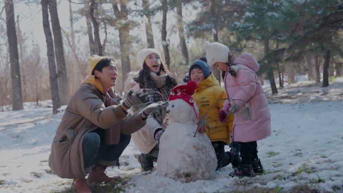 快乐家庭在雪地里堆雪人