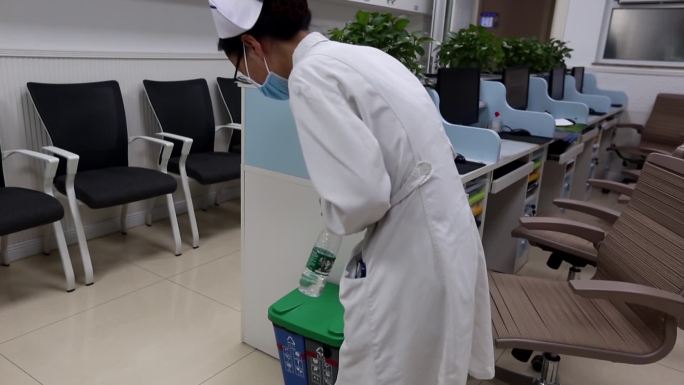 医院医生护士把垃圾投放进分类垃圾桶内
