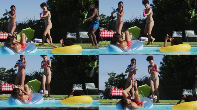 混合种族的女人玩水枪在游泳池里
