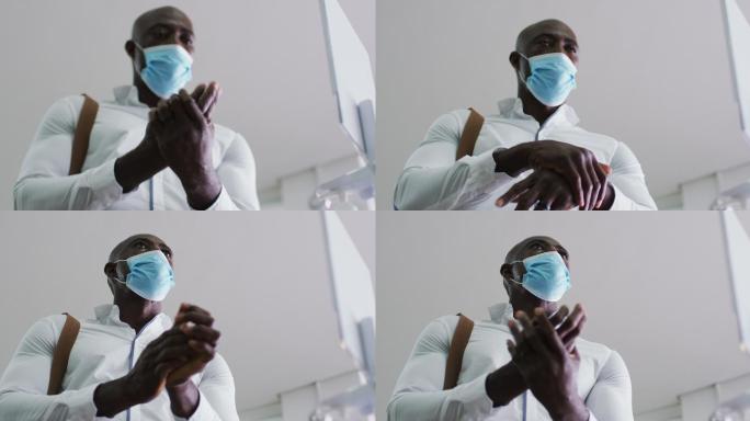 非裔美国商人戴着口罩在办公室消毒双手