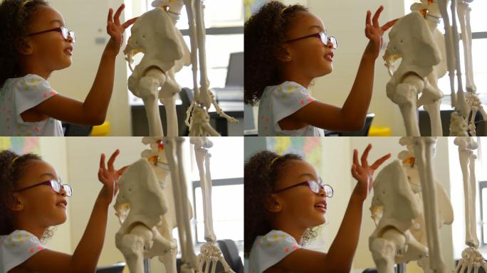 侧面的非洲裔美国女学生学习人体骨骼在教室在学校4k