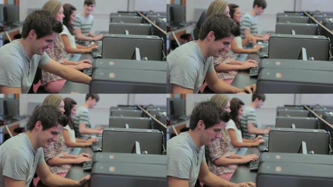 大学计算机课上的学生们，一个男人正对着镜头微笑