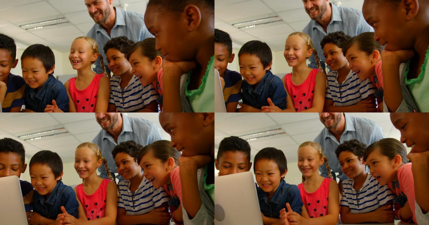 成年白人男性教师在教室里用笔记本电脑教孩子们