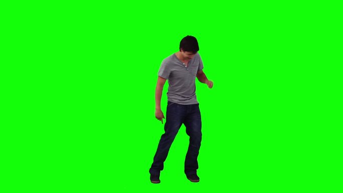 一个快乐的年轻人在绿色的背景下跳舞