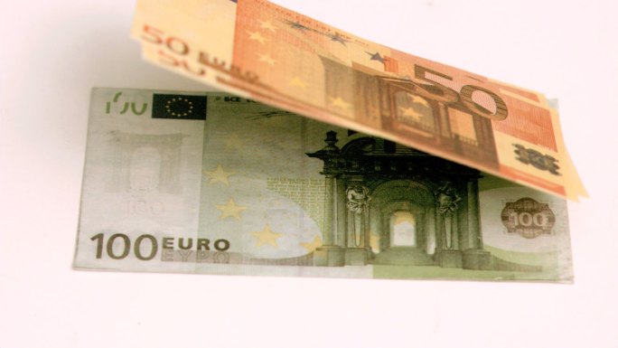 欧洲钞票在白色背景下以超级慢动作吹出
