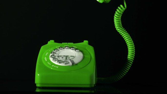 绿色电话的听筒起掉落在电话上特写