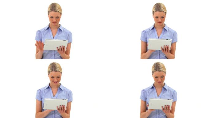 金发女子在白色背景下使用平板电脑