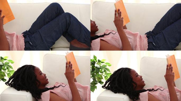 一个黑人女性在沙发上躺着看书