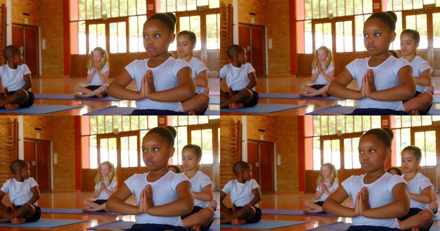 学校里的孩子们在运动垫上练习瑜伽