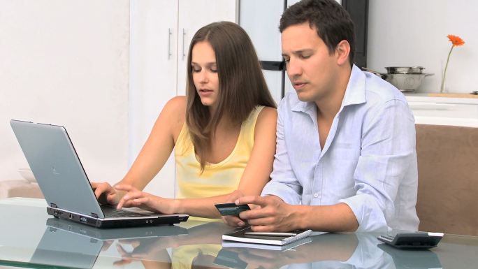 夫妻坐在一起用电脑购物特写
