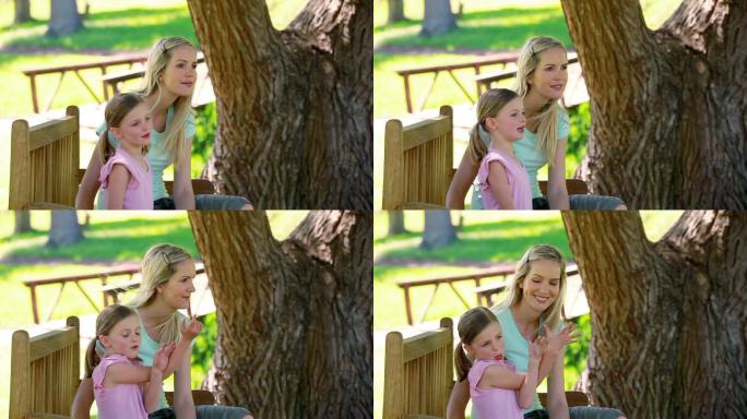 一个年轻女子和她的妹妹坐在公园的长椅上