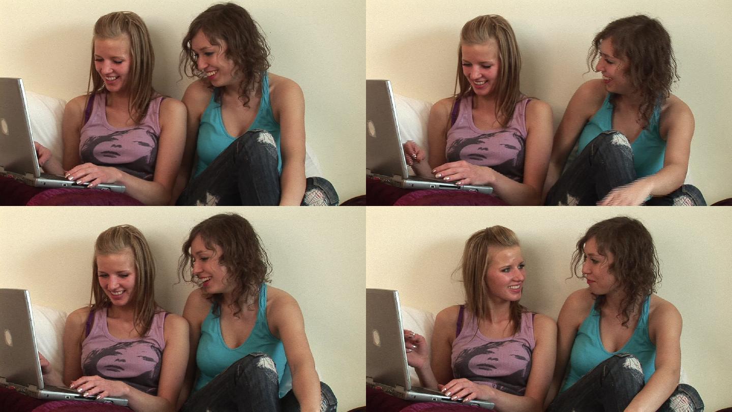 两个女孩在床上用电脑特写