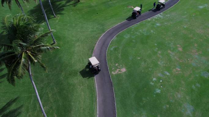 航拍高尔夫运动员驾驶高尔夫球车
