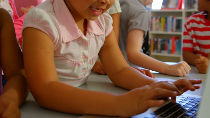 女学生在学校图书馆的桌子上一起用笔记本电脑学习4k
