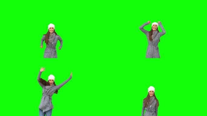 绿色屏幕下女人穿着冬装跳起欢呼特写