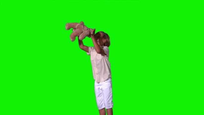 可爱的男孩跳跃和捕捉泰迪熊在绿色屏幕上的慢动作