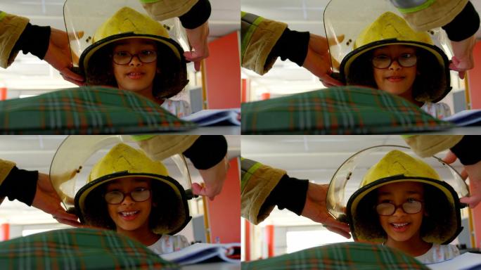消防员帮助非裔美国女学生在教室里戴上头盔